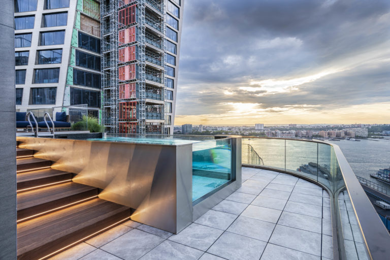 Rooftop terrace with a pool overlooking the New York City skyline