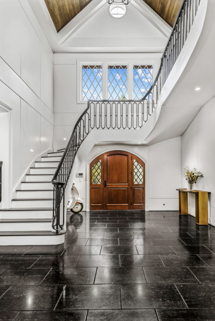 Home foyer with black tiles and white staircase