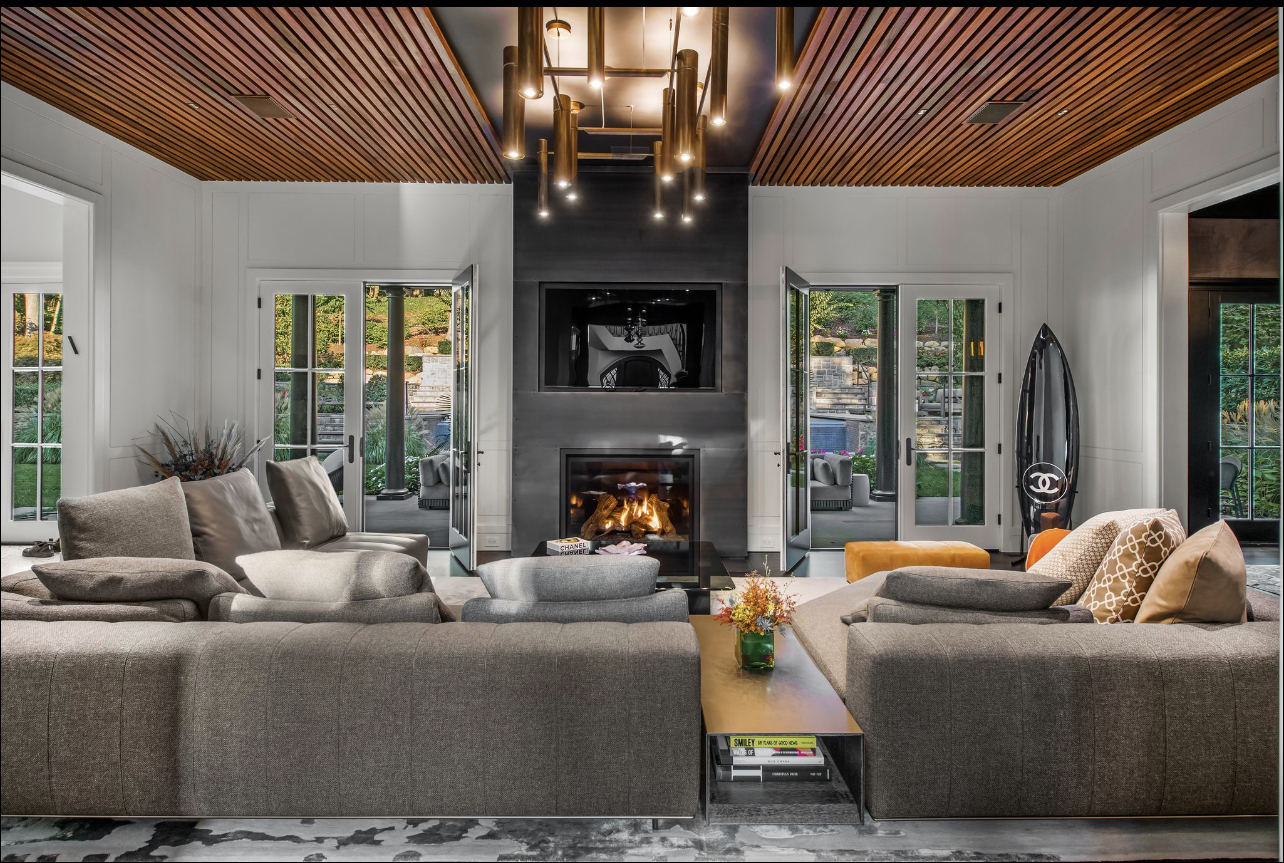 Living room with large fireplace and wood paneled ceiling at Roslyn Harbor