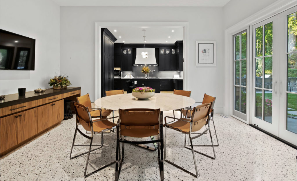 Eat in kitchen design with white flooring and doors out to the patio