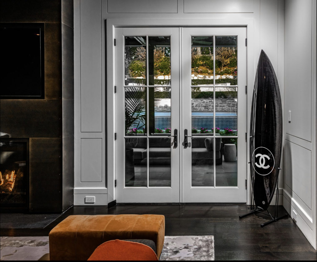 Corner of living room with a Chanel surfboard by the double doors