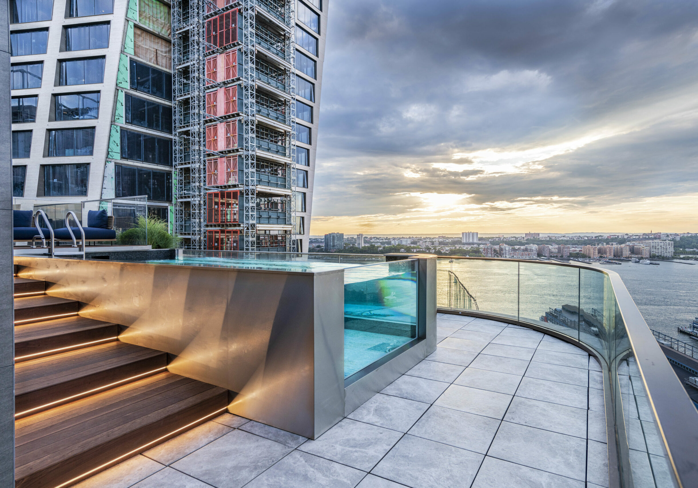 Rooftop terrace with a pool overlooking the New York City skyline